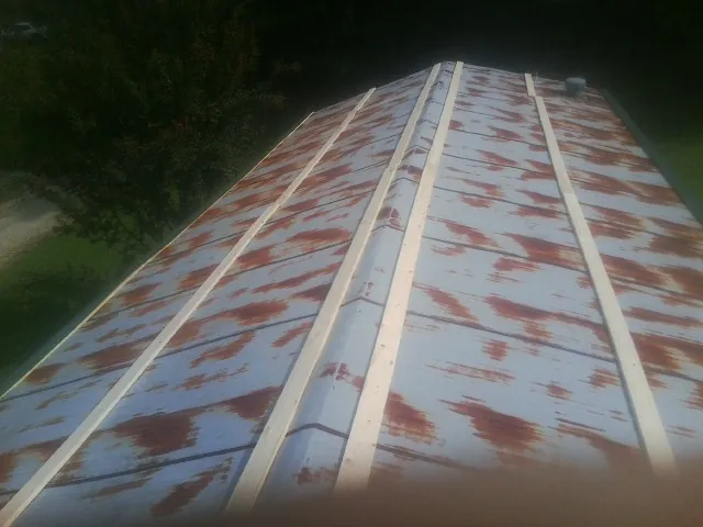 Rusted metal roof panels with new wood purlins before replacement — Storm Damage Roof Repair in South Whitley by Roofing Brothers