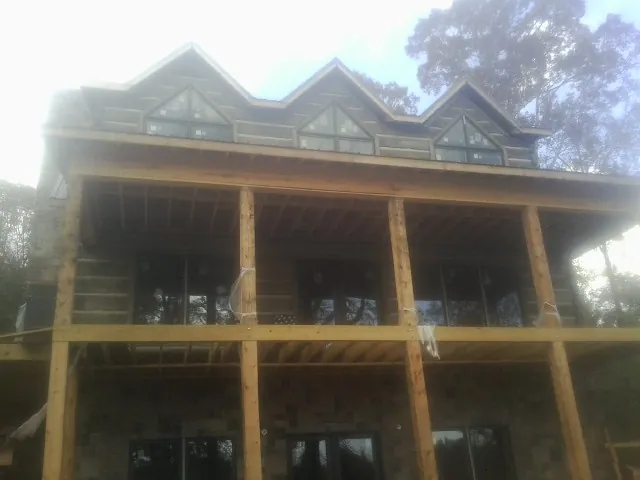 Dormers and porch framing on a large log home under construction — Roof Coating work by our crew in South Whitley