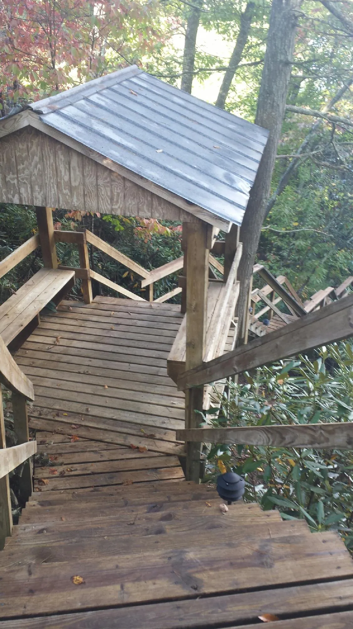 Metal roofed shelter over wooden steps on a wooded walkway — Skylight Repair & Installation work by our crew in South Whitley
